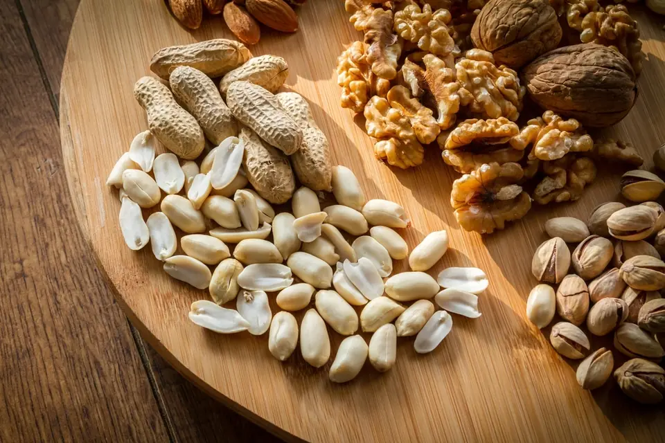 Peanuts, walnuts and pistachios on a round wooden board